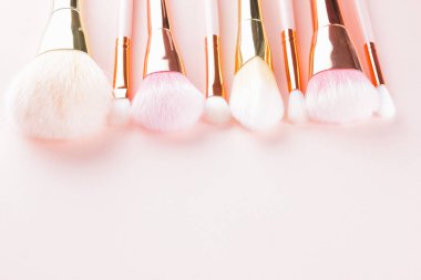 Makyaj pembe arka plan fırçalar. Altın makyaj fırçaları, dizi kavramı. Kadın güzellik Aksesuar pastel renklerde. Uzay kopyalayın. Düz yatıyordu