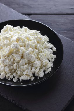 Süzme peynir siyah arduvaz gemide. Peynir siyah plaka üzerinde. Yumuşak peynir diyet siyah panoları için. Kahvaltı için sağlıklı süt ürünleri. Kavramı