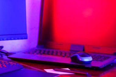 İşyeri dijital Tasarımcısı. Freelancer işyerinde neon ışık. Bilgisayar, grafik tablet ve smartphone masanın üzerinde. Mavi pembe ışık yaratıcılık için yer