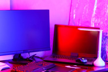 İşyeri dijital Tasarımcısı. Freelancer işyerinde neon ışık. Bilgisayar, grafik tablet ve smartphone masanın üzerinde. Mavi pembe ışık yaratıcılık için yer