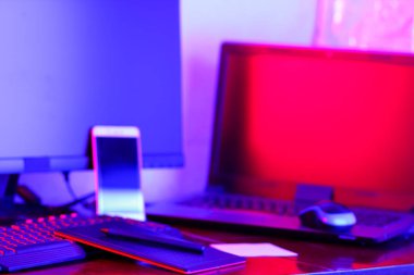 İşyeri dijital Tasarımcısı. Freelancer işyerinde neon ışık. Bilgisayar, grafik tablet ve smartphone masanın üzerinde. Mavi pembe ışık yaratıcılık için yer