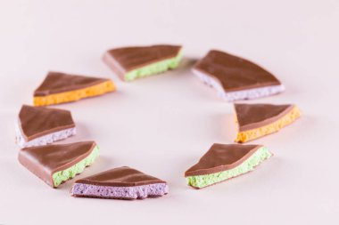 Meyve, pembe arka plan dolgu çikolata. Çikolata ile yaban mersini, nane ve portakal dilimleri. Pastel renk arka plan üzerinde koyu çikolata. Kavramı