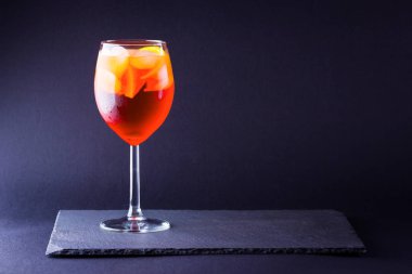 Kokteyl aperol spritz koyu arka plan üzerinde. Yaz alkol minimalizm tarzı turuncu meyve kokteyli. İtalyan kokteyl aperol spritz kayrak gemide. Kopya alanı