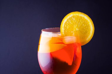 Kokteyl aperol spritz koyu arka plan üzerinde. Yaz alkol portakal dilimleri ile kokteyl. İtalyan kokteyl aperol spritz kayrak gemide. Modaya uygun içecek