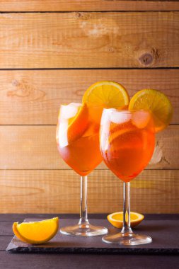Kokteyl aperol spritz ahşap kurullarında. İki bardak portakal dilimleri ile yaz alkollü kokteyl ile. İtalyan kokteyl aperol ahşap arka plan üzerinde spritz. Eğilim içki