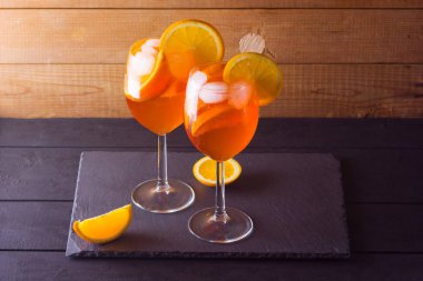 Kokteyl aperol spritz ahşap kurullarında. İki bardak portakal dilimleri ile yaz alkollü kokteyl ile. İtalyan kokteyl aperol ahşap arka plan üzerinde spritz. Eğilim içki