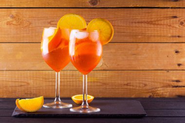 Kokteyl aperol spritz ahşap kurullarında. İki bardak portakal dilimleri ile yaz alkollü kokteyl ile. İtalyan kokteyl aperol ahşap arka plan üzerinde spritz. Eğilim içki