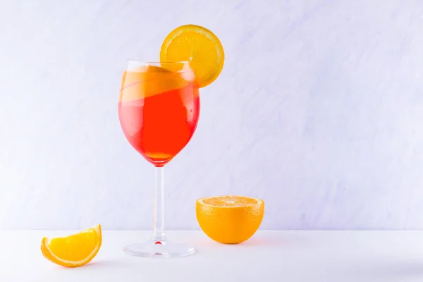 Cocktail aperol spritz on white background. Summer alcoholic cocktail with orange slices. Italian cocktail aperol spritz on white board. Trend drink