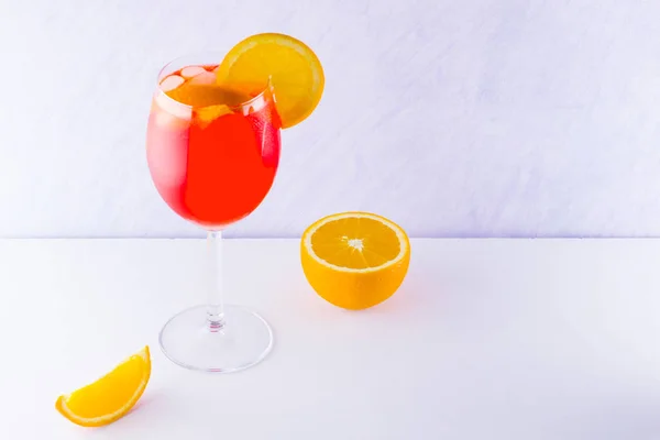 Cocktail aperol spritz on white background. Summer alcoholic cocktail with orange slices. Italian cocktail aperol spritz on white board. Trend drink