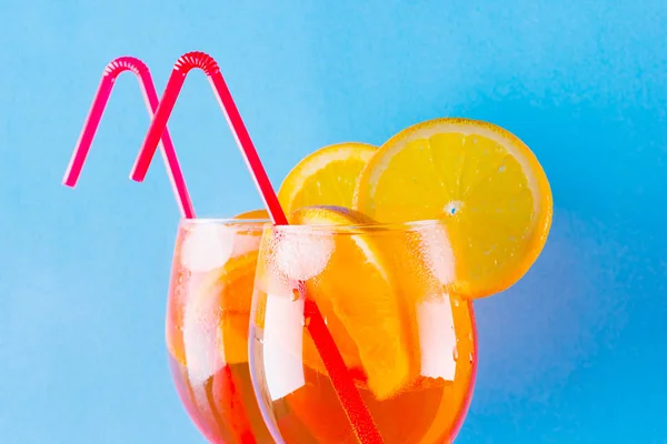 鸡尾酒杯在蓝色背景上的冲刺 夏季酒精鸡尾酒 配橘子片 在彩色背景上的阿佩罗斯普里茨 简约风格的珊瑚色鸡尾酒 — 图库照片