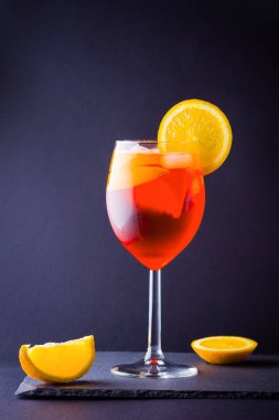Kokteyl aperol spritz koyu arka plan üzerinde. Yaz alkol portakal dilimleri ile kokteyl. İtalyan kokteyl aperol spritz kayrak gemide. Modaya uygun içecek