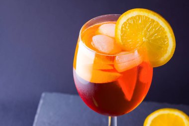 Kokteyl aperol spritz koyu arka plan üzerinde. Yaz alkol portakal dilimleri ile kokteyl. İtalyan kokteyl aperol spritz kayrak gemide. Modaya uygun içecek