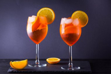 Siyah tahta üzerinde kokteyl Aperol Spritz. Portakal dilimleri ile yaz alkol kokteyli. İtalyan kokteyl Aperol Spritz arduvaz kurulu. Trendy içecek
