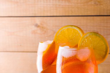 Kokteyl aperol spritz ahşap kurullarında. İki bardak portakal dilimleri ile yaz alkollü kokteyl ile. İtalyan kokteyl aperol ahşap arka plan üzerinde spritz. Eğilim içki