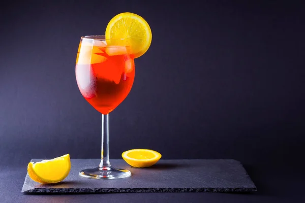 暗い背景にカクテル Aperol スプリッツ 夏アルコール カクテル オレンジ スライス イタリアのカクテル Aperol はスレート板でさっと振りかけます — ストック写真