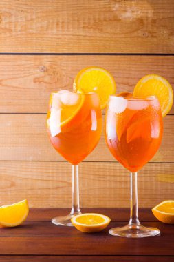 Kokteyl aperol spritz ahşap kurullarında. İki bardak portakal dilimleri ile yaz alkollü kokteyl ile. İtalyan kokteyl aperol spritz ahşap arka plan üzerinde