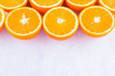 Portakal meyvelerinin arka planı. Taze portakallar birçok yarısı, üst görünüm. Meyve suyu yapmak için narenciye. Beyaz bir arka planda dilimlenmiş portakallar bir sürü. Kavram