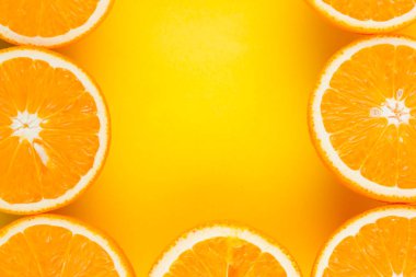 Sarı arka planda sulu turuncu yarısını keser. Turuncu meyve, narenciye minimal kavramı. Yaratıcı yaz yemekleri minimalist arka plan. Üst görünüm, düz yatıyordu