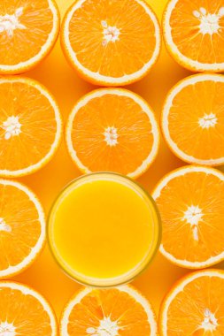 Sarı arka planda sulu turuncu yarısını keser. Turuncu meyve, narenciye minimal kavramı. Yaratıcı yaz yemekleri minimalist arka plan. Üst görünüm, düz yatıyordu