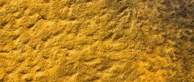 Altın taş yüzey dokusu. Altın renginde doğal arka plan. Retro tarzında taş duvar dokusu. Geniş ekran