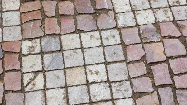 Paving stones in the old European city. Background from paving stones. Stone road in the old town. Stone pattern