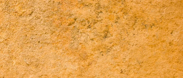 Altın taş yüzey dokusu. Altın renginde doğal arka plan. Retro tarzında taş duvar dokusu. Geniş ekran
