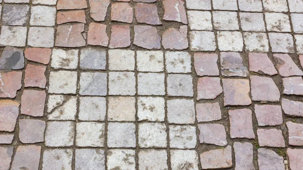 Paving stones in the old European city. Background from paving stones. Stone road in the old town. Stone pattern