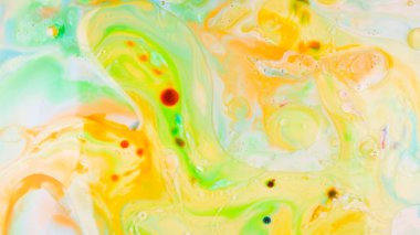 Sıvı üzerine yağ ile çok renkli arka plan. Sıvı üzerine soyut altın yeşil arka plan. Çok renkli noktalar ile Desen. Akışkan sanat