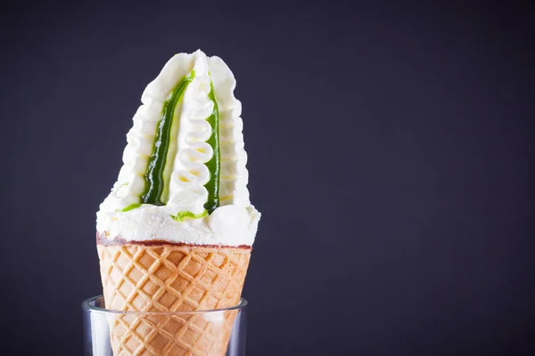 Ice cream cone on black background. Ice cream with jam, summer concept. Waffle cone with dessert in glass. Minimalism