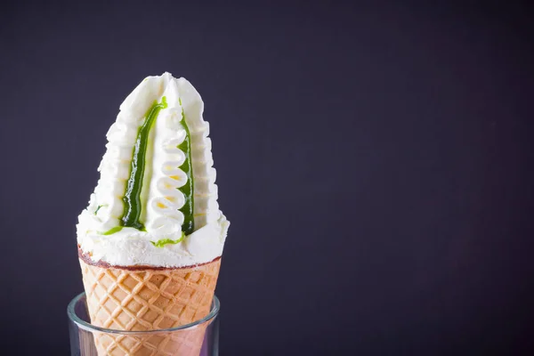 Ice cream cone on black background. Ice cream with jam, summer concept. Waffle cone with dessert in glass. Minimalism