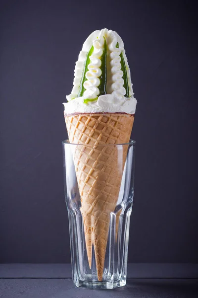 Ice cream cone on black background. Ice cream with jam, summer concept. Waffle cone with dessert in glass. Minimalism