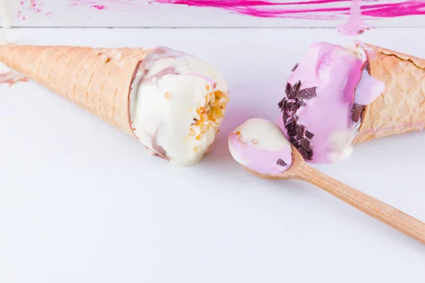 Melted ice cream on a pink white background. Two ice cream cones in pop art style. Summer milk dessert with wooden spoon. Summer concept