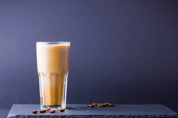 暗い背景にミルクとアイスコーヒー スレートボードにカフェインを入れた夏の飲み物 グラスカップにラテとコーヒー豆 スペースのコピー — ストック写真
