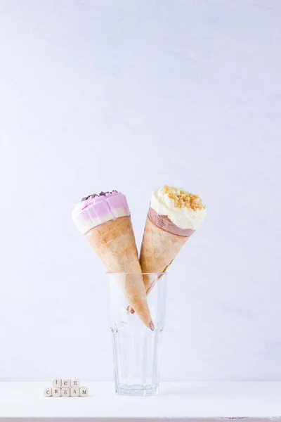 Jäätelöä Suklaalla Pähkinöillä Valkoisella Pohjalla Kaksi Jäätelötötteröä Lasissa Kesämaitojälkiruoka Vohvelikartiossa — kuvapankkivalokuva