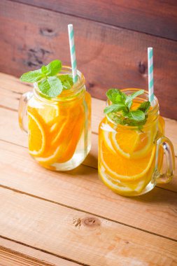 Portakal, limon ve nane ile meyve infakit su. Ahşap tahtaları nane ile mix meyveler lezzetli ferahlatıcı içecek kupa. Mason kavanoz içinde buzlu yaz içeceği. Taze ev yapımı limonata