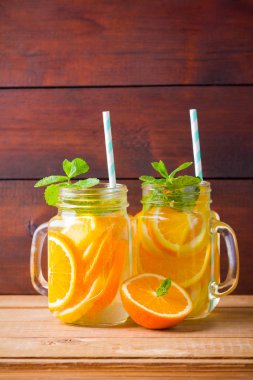 Portakal, limon ve nane ile meyve infakit su. Ahşap tahtaları nane ile mix meyveler lezzetli ferahlatıcı içecek kupa. Mason kavanoz içinde buzlu yaz içeceği. Taze ev yapımı limonata