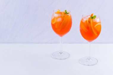 Beyaz bir arka plan üzerinde nane yaprakları ile Aperol Spritz kokteyl. Portakal dilimleri ile yaz alkol kokteyli bir bardak. Klasik İtalyan içecek mercan rengi
