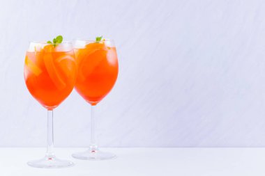 Beyaz bir arka plan üzerinde nane yaprakları ile Aperol Spritz kokteyl. Portakal dilimleri ile yaz alkol kokteyli bir bardak. Klasik İtalyan içecek mercan rengi
