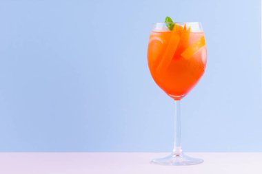 Kokteyl Aperol Spritz mavi pembe arka plan üzerinde. Pop art tarzı İtalyan kokteyl aperol spritz. Pastel arka planda yaz trendy içki