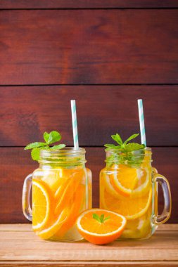 Portakal, limon ve nane ile meyve infakit su. Ahşap tahtaları nane ile mix meyveler lezzetli ferahlatıcı içecek kupa. Mason kavanoz içinde buzlu yaz içeceği. Taze ev yapımı limonata