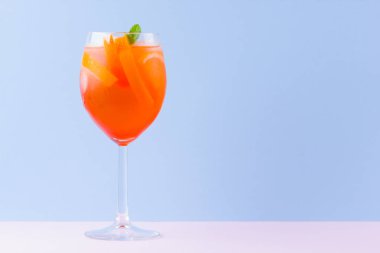 Kokteyl Aperol Spritz mavi pembe arka plan üzerinde. Pop art tarzı İtalyan kokteyl aperol spritz. Pastel arka planda yaz trendy içki