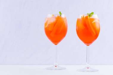 Beyaz bir arka plan üzerinde nane yaprakları ile Kokteyl Aperol Spritz. Beyaz arka planda İtalyan kokteyl aperol spritz