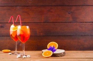 Ahşap tahtalarda kokteyl aperol spritz. Turuncu dilimler ve çiçekler ile yaz alkollü kokteyl. Ahşap tahtalarda Aperol spritz