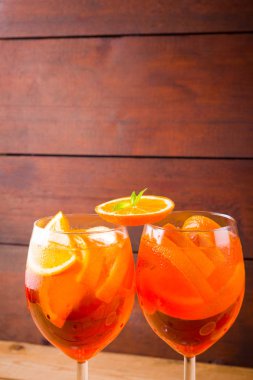 Ahşap tahtalarda kokteyl aperol spritz. Turuncu dilimler ve çiçekler ile yaz alkollü kokteyl. Ahşap tahtalarda Aperol spritz
