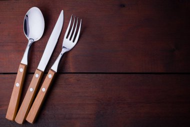 Rustik çatal bıçak, kaşık, çatal seti. Ahşap kulplu yemek takımı. Ahşap arka plan. Kopya alanı. Üstte görüntü