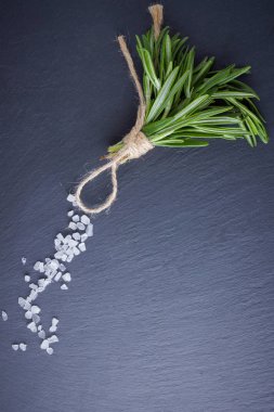 Biberiye demeti siyah bir arka plan üzerinde ip ile bağlı. Taze biberiye ve arduvaz taşında tuz. Kopya alanı ile et yemekleri pişirmek için otlar. Üstte görüntü