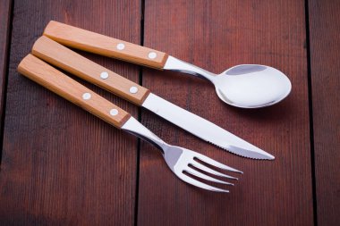 Rustik çatal bıçak, kaşık, çatal seti. Ahşap kulplu yemek takımı. Ahşap arka plan. Kopya alanı. Üstte görüntü