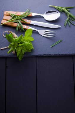 Çatal bıçak, kaşık, kayrak taş üzerinde çatal seti. biberiye ile utlery. Siyah arka plan. Kopya alanı. Üstte görüntü