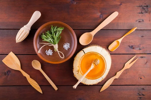 Wooden cutlery, top view. Cutlery, rosemary and honey on wooden boards. Eco concept with natural materials. Flat lay