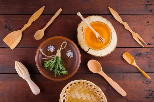 Wooden cutlery, top view. Cutlery, rosemary and honey on wooden boards. Eco concept with natural materials. Flat lay